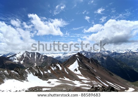 Rocks, snow, clouds and sky in Caucasus mountains Elbrus area. Caucasus mountains.
