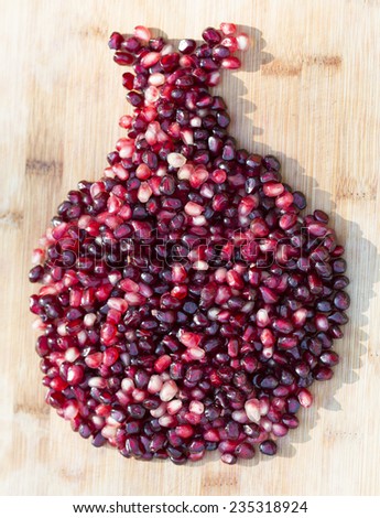 pile of pomegranate seeds in shape of a pomegranate on a bamboo background