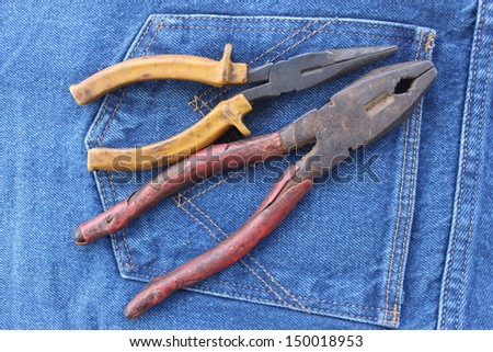 old tool wrenches in the pocket of blue jeans
