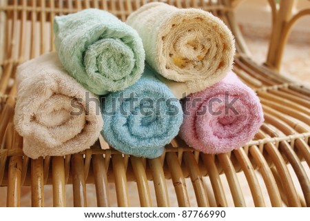 Multicolour towels rolls on wood chair