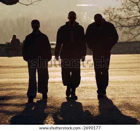 Three friends in shadow at sunset