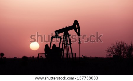 Oil pump, industrial machine for petroleum in the sunset background