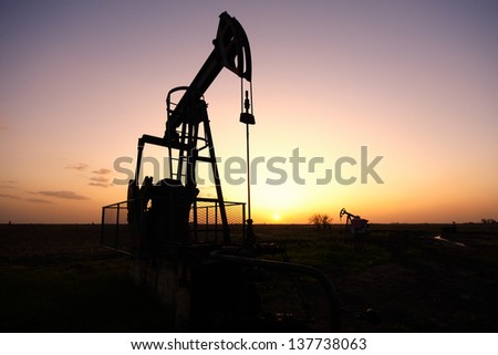 Oil pump, industrial machine for petroleum in the sunset background