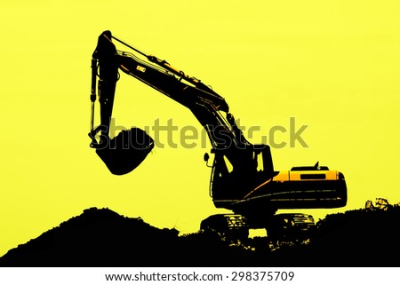 Excavator loader machine during earth moving works outdoors at construction site, silhouette
