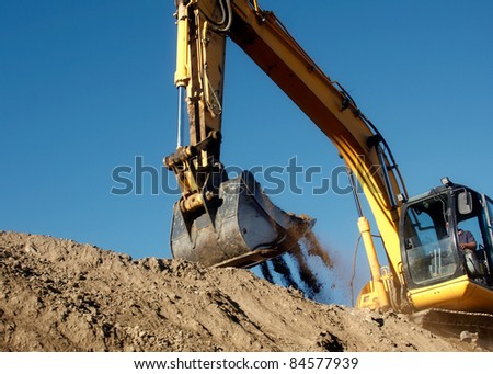 Excavator digging the earth with the sky in the background