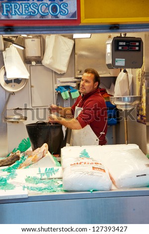 MALAGA, SPAIN - MARCH 31: An unidentified seller packs the fishes at his shop in the popular central market on March 31, 2012 in Malaga, Spain.It was renovated in 2010