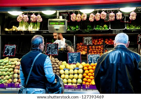 MALAGA, SPAIN - MARCH 31: Unidentified sellers pack fruits at their shop in the popular central market on March 31, 2012 in Malaga, Spain. It was renovated in 2010 and it was reopened on March 2011.