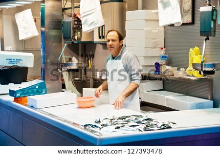 MALAGA, SPAIN - MARCH 31: An unidentified seller packs the fishes at his shop in the popular central market on March 31, 2012 in Malaga, Spain.It was renovated in 2010.