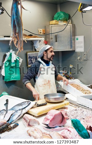 MALAGA, SPAIN - MARCH 31: An unidentified seller packs the fishes at his shop in the popular central market on March 31, 2012 in Malaga, Spain.It was renovated in 2010.