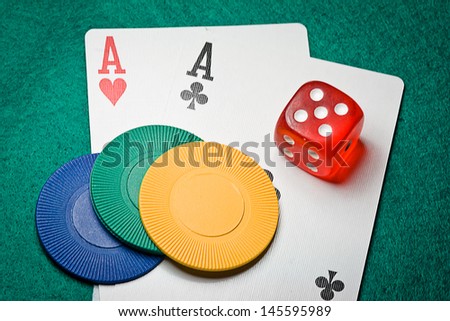 Pair of aces and poker chips on a green table in casino
