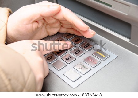 woman hand entering pin code in a ATM