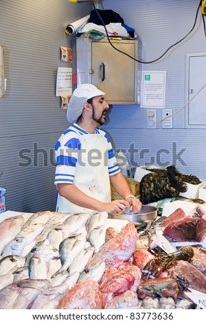 MALAGA, SPAIN - JUNE 10:An unidentified seller packs the fishes at his shop in the popular Central Market on June 10, 2011 in Malaga,Spain.It was renovated in 2010 and it was reopened on March 2011.