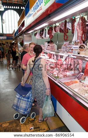 MALAGA, SPAIN - JUNE 10: Unidentified sellers pack meat at their shop in the popular central market on June 10, 2011 in Malaga, Spain. It was renovated in 2010 and it was reopened on March 2011.