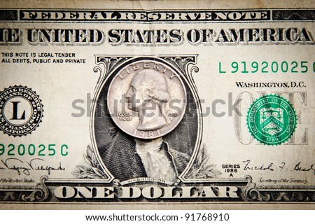 close-up of quarter dollar coin on the one dollar bill