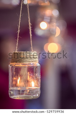 Wedding decoration in the form of glass jars with burning candles inside