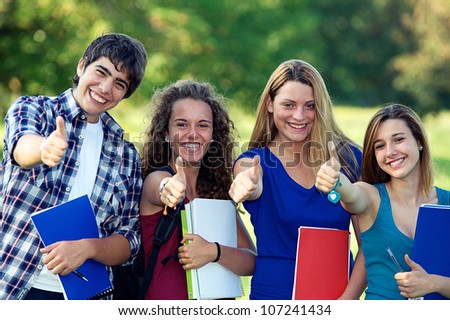 Young group of happy students showing thumbs up sign together outdoor in the park Italy