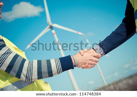 Engineers giving Handshake in a Wind Turbine Power Station Italy
