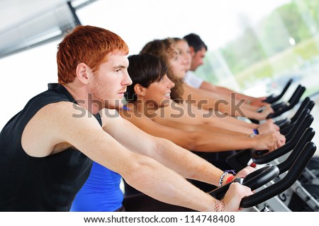 Group of five people in the gym, exercising their legs doing cardio training,Italy
