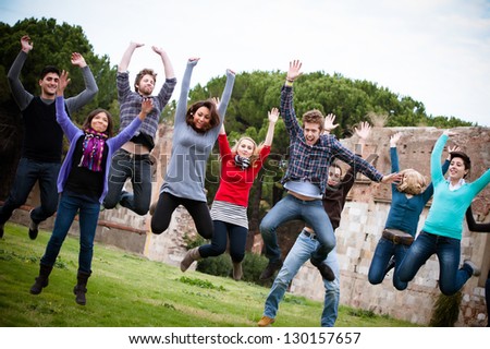 Group of Happy College Students Jumping at Park,Italy