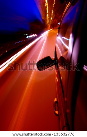 Motion blur of lights at night.    camera mounted on vehicle. Focus on mirror