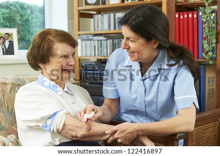 Nurse treating elderly womans\' injury