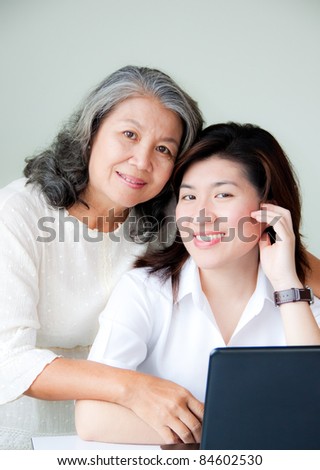 smiling two asian women with notebook