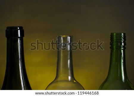 Picture of wine bottle necks on a row, on a yellow and black background