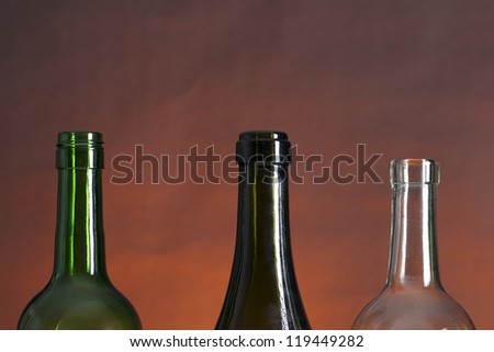 Picture of wine bottle necks on a row, on a red and black background
