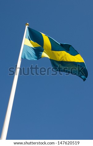 Picture of Swedish flag waving in the wind, on a blue sky  Picture of Swedish flag waving in the wind, on a blue sky