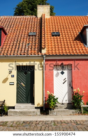 Picture of a small yellow house and a small red house