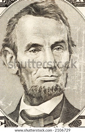 Abraham Lincoln\'s portrait on front of a five dollar bill.