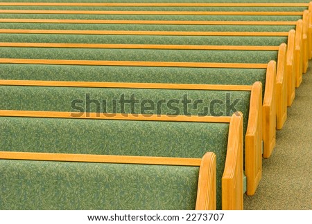 Many rows of empty church pews.