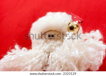 Santa clause rag doll with bell hat, on a red background.