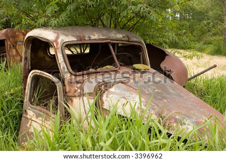 Abandoned rusty truck in field of grass