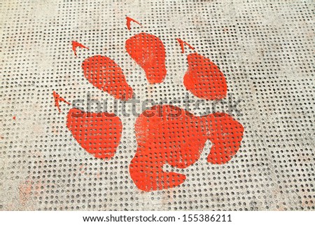 Red animal footprints on rough cement floor background