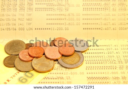 Bank saving account passbook with lot of coins above