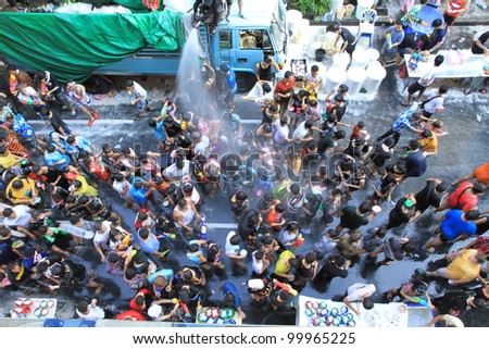 BANGKOK - APRIL 13: Stream of water over the crowd of people during celebrating the traditional Songkran New Year Festival, April 13, 2012, Silom road, Bangkok, Thailand.