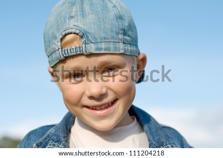 Five year old boy laughs. Against the blue sky