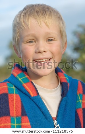Five year old boy laughs. A walk in the garden