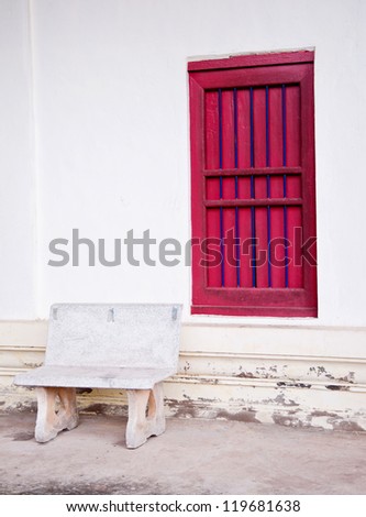 stone chair and red window