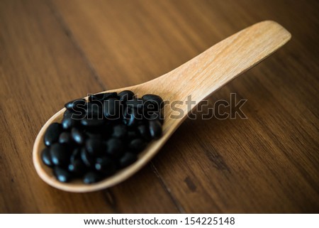 Coffee beans in wood spoon on wood backgrounds