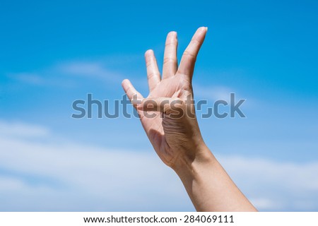 Four fingers on blue sky