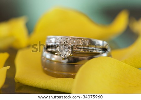 stock photo an engagement and wedding ring macro shot on yellow flower 