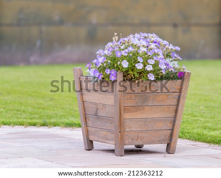 wooden planter with purple flowers on patio