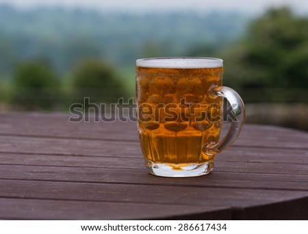 traditional pint of bitter beer on country pub beer garden table