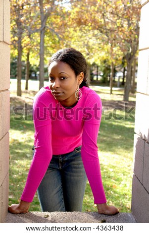 A picture of a pretty woman leaning forward i jeans an pink blouse