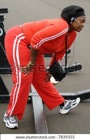 A big woman exercising in red jogging suit