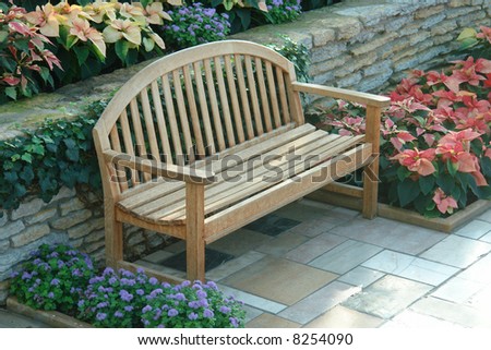A picture of a bench in a flower garden