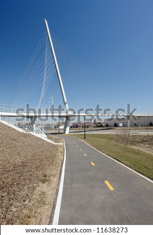 A picture of a trail leading to a bike and foot bridge crossing freeway