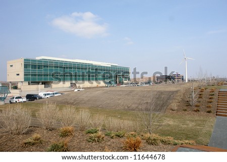 A picture of a corporation with windmill on open land